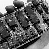 icon to link to B&W photo of angled view of top of assembled CPU board held in a hand